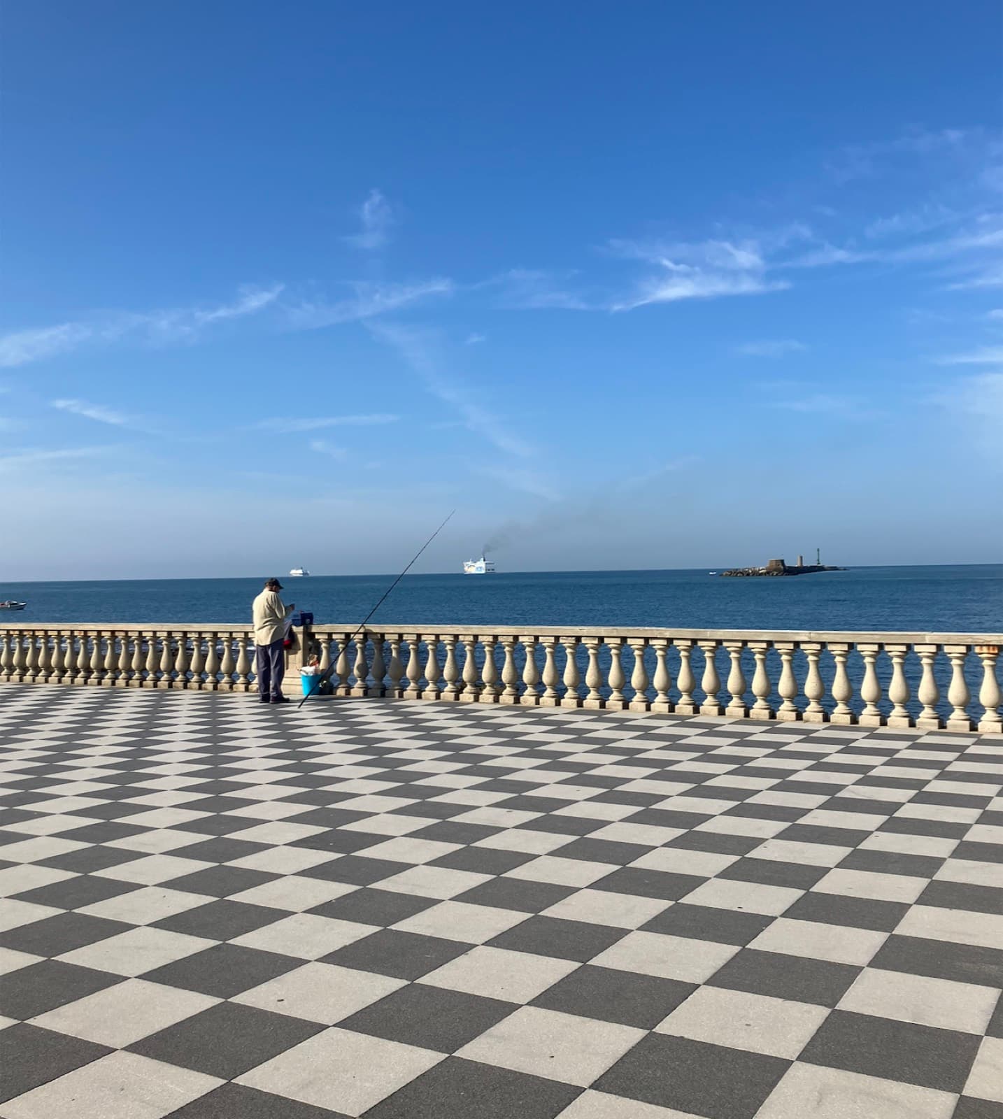 The chequerboard terrace at Livorno, a man fishing from the balustrade, ships on the horizon