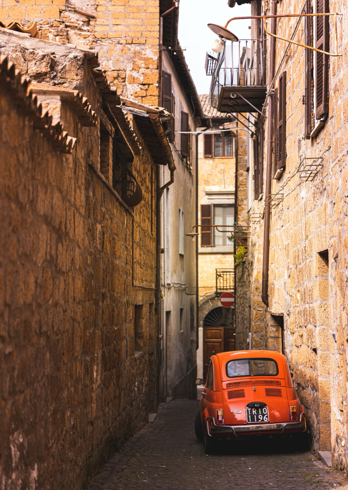 A car inside the old walls, on a street built for feet. This is the picture the ZTL cameras exist to prevent.